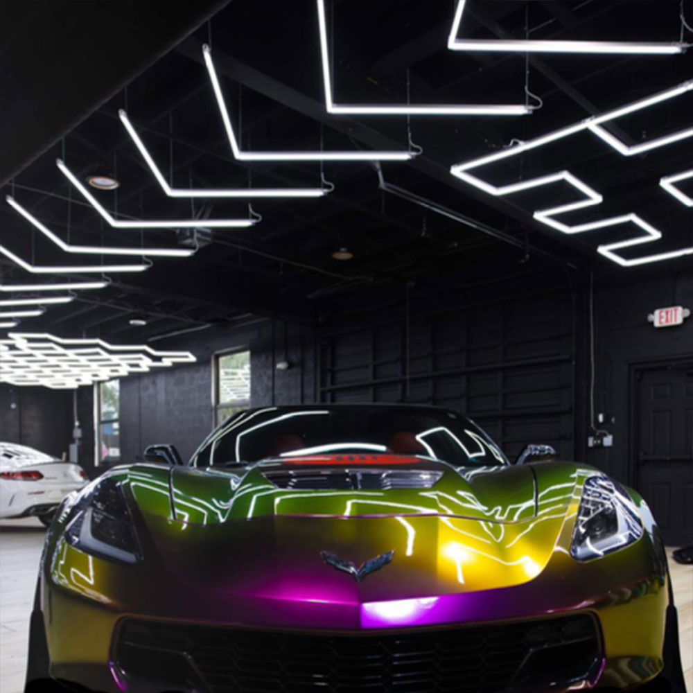 A colorful Chevrolet Corvette parked in a garage, illuminated by "Arrow" LED Hex Lights.