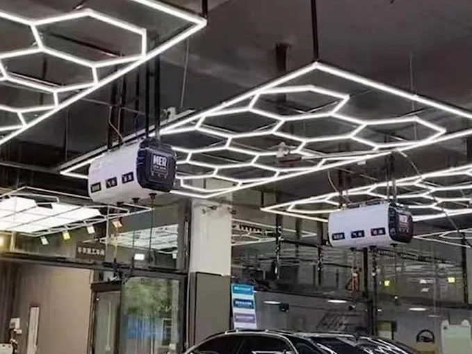 A car is parked in a parking garage, illuminated by custom hex lighting.