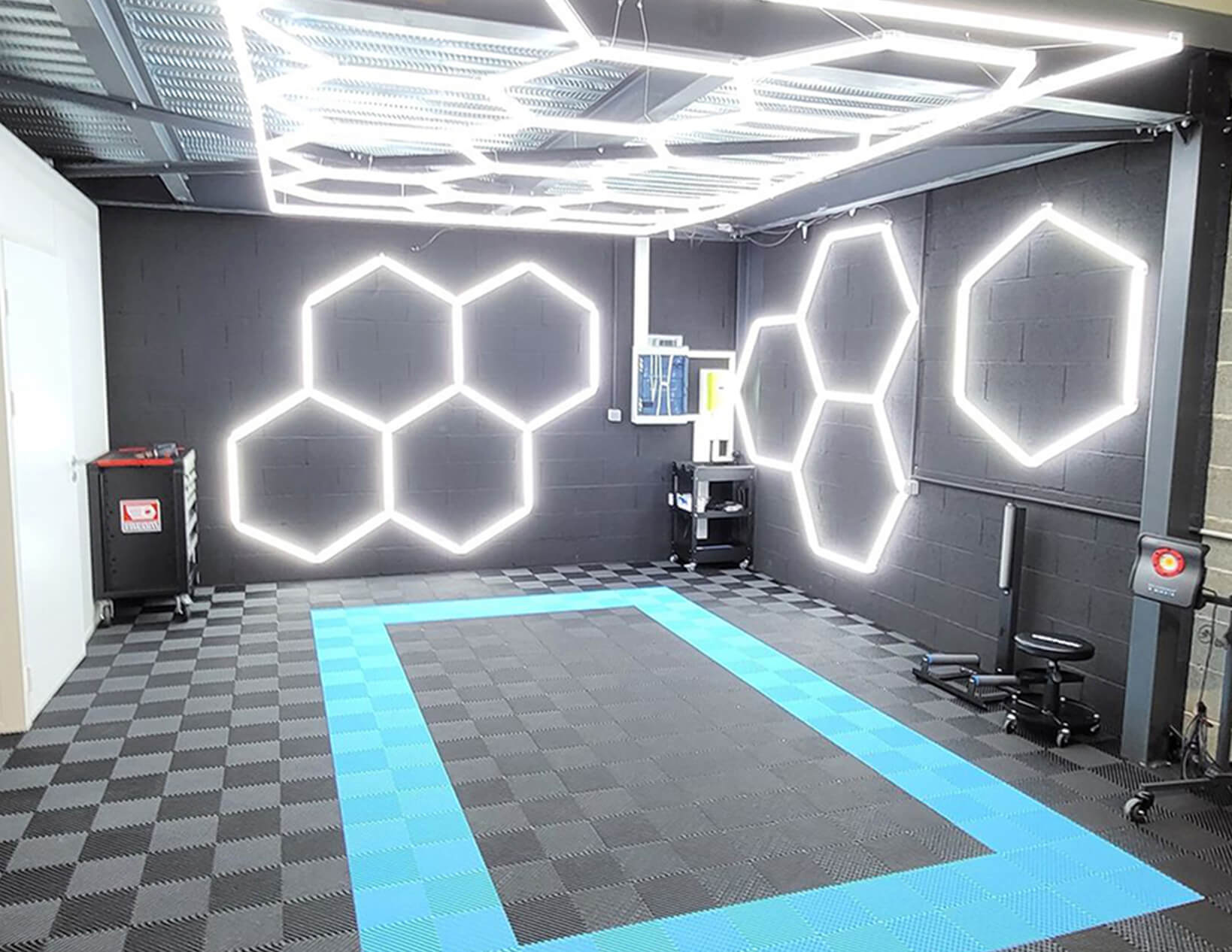 A gym room with a blue and black floor and Canada Hex Lights.