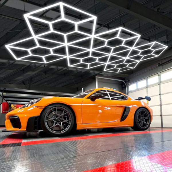 A Porsche Cayman parked in a garage, illuminated by "Honey Money" LED Hex Lights.